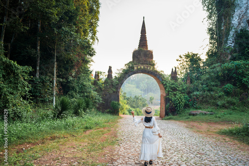 Asian female tourist standing at The large ancient pagoda arch is beautiful, Khao Na Nai Luang Dharma Park, Surat Thani, Thailand.