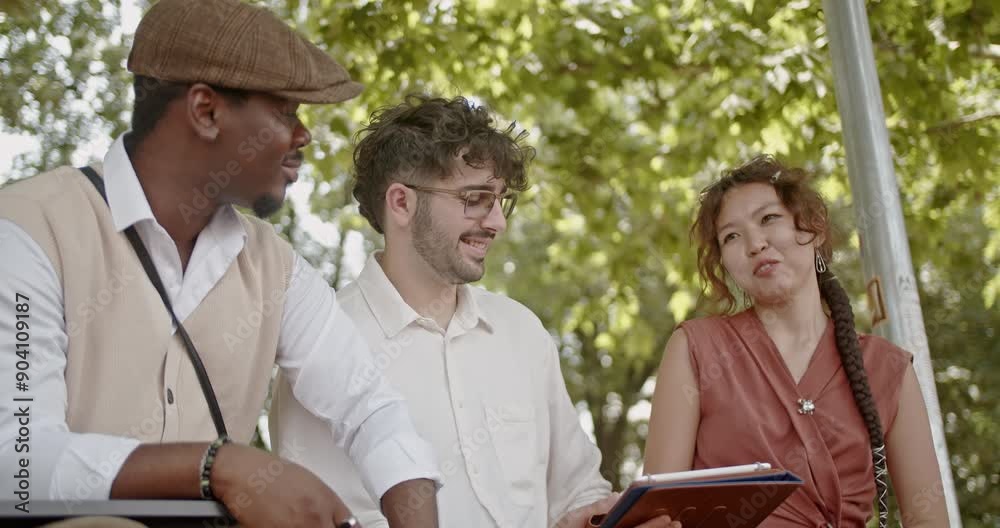 A group of friends from various backgrounds is happily conversing and laughing outdoors, capturing candid moments of joy and friendship on a sunny day in a beautiful natural setting. A group of friends from various backgrounds is happily conversing and laughing outdoors, capturing candid moments of joy and friendship on a sunny day in a beautiful natural setting.