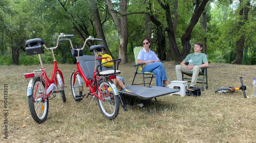 Family bike ride in the park. Mother with two sons riding bicycles on the path in summer. Simferopol, Crimea, Russia 2024 Family bike ride in the park. Mother with two sons riding bicycles on the path in summer. Simferopol, Crimea, Russia 2024