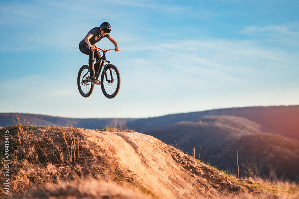 Young man flying through the air on a mountain bike