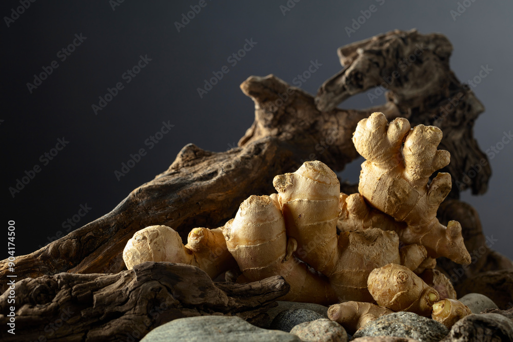 Ginger root with old snags and stones on a black background. Ginger root with old snags and stones on a black background.