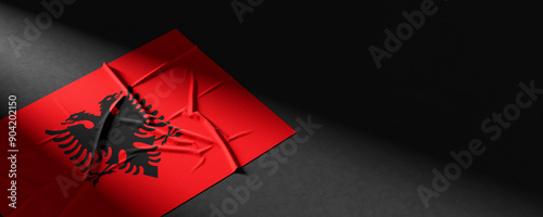 Flag of Albania. Fabric textured Albania flag isolated on dark background. 3D illustration