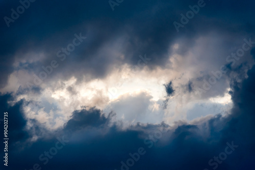 Dark and Dramatic Storm Clouds framing a clear sky Area Background photo