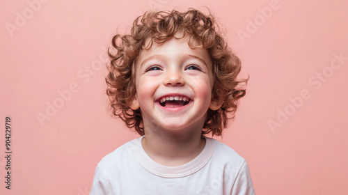 Cheerful boy with a pastel pink backdrop photo