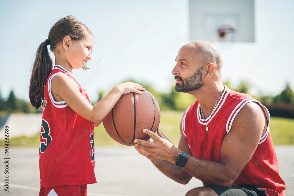 Basketball, sport with a dad and daughter training on a court outside for leisure fitness and fun Basketball, sport with a dad and daughter training on a court outside for leisure fitness and fun