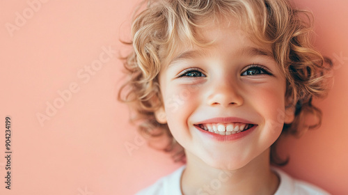 Grinning boy with a soft pink backdrop