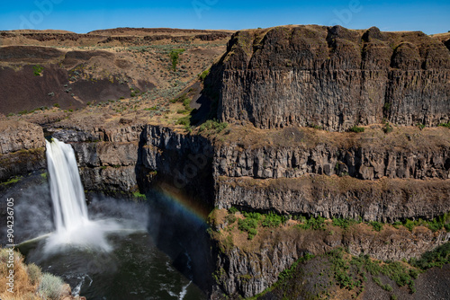 silky waters of Palouse Falls  flowing from the basalt canyon toward the Snake River with a rainbow on the side in Washington State photo