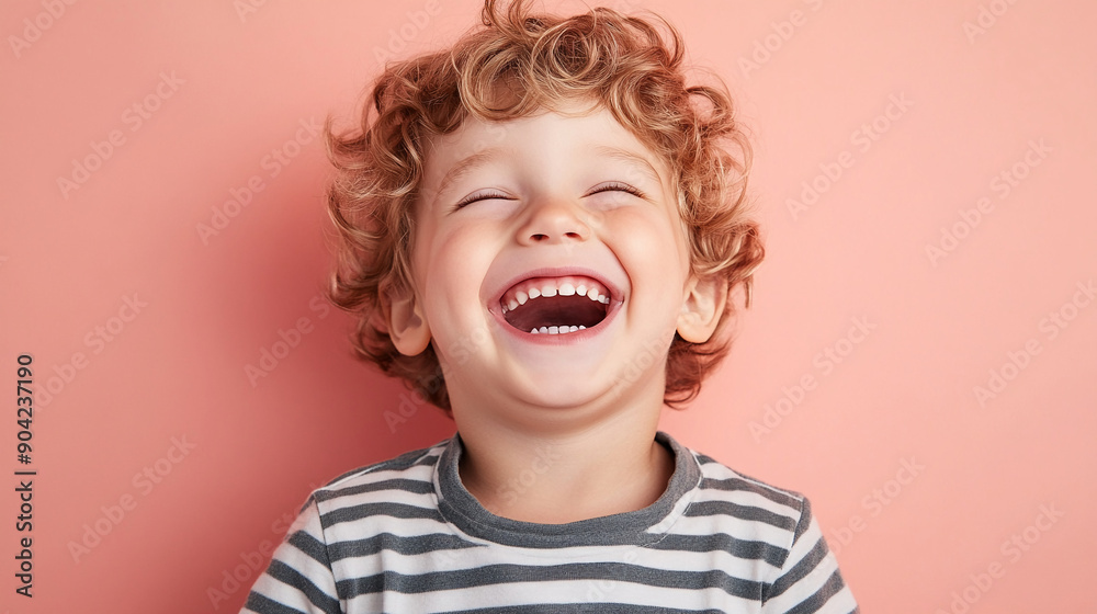 Laughing boy against a soft pink backdrop