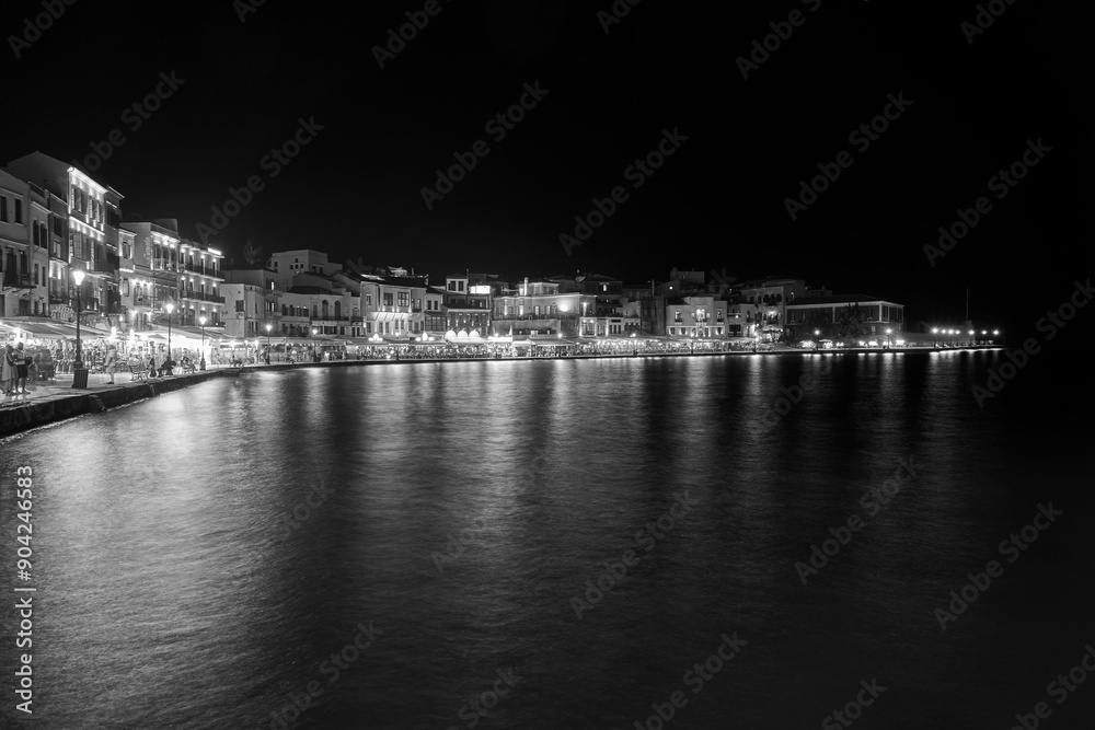 Fototapeta premium Tourists, taverns and houses at night in the port of Chania city