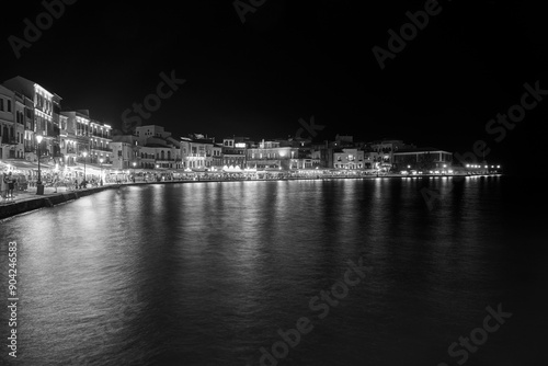 Tourists, taverns and houses at night in the port of Chania city