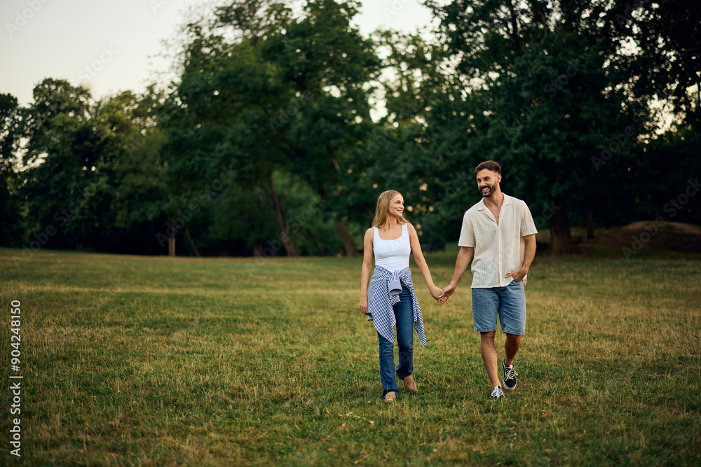 Two lovers enjoying the day, holding hands and walking through the park. Two lovers enjoying the day, holding hands and walking through the park.