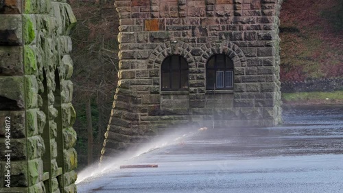 Views of the famous Howden and Derwent stone build Dams, used in the filming of the movie Dam Busters. Showing water overflowing over the dam walls with victorian towers on each side of the structure photo