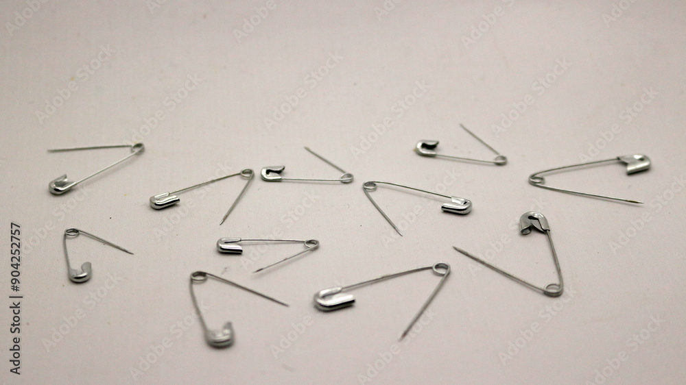 Fototapeta premium The safety pin is made of metal and silver in color.