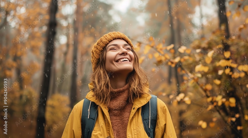Enthusiastic woman with a big smile, embracing the cool rain while exploring a forest draped in autumn hues Enthusiastic woman with a big smile, embracing the cool rain while exploring a forest draped in autumn hues