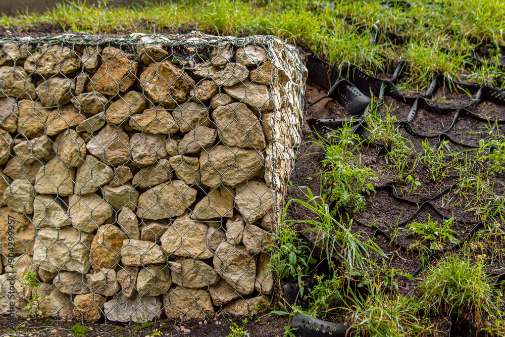 Gabion fence and black geogrid. Strengthening the slope Gabion fence and black geogrid. Strengthening the slope