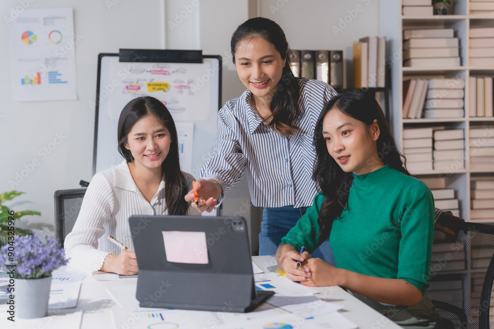 Marketing team is collaborating on a project, using a digital tablet to analyze data and develop their strategy Marketing team is collaborating on a project, using a digital tablet to analyze data and develop their strategy