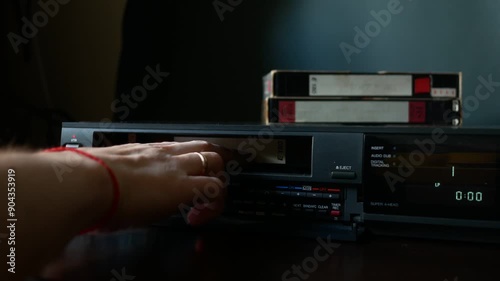 Loading a video cassette into a VCR.
