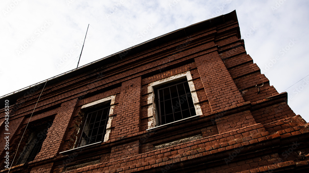 A Beautiful Brick Building Facade Standing Tall Against a Dramatic Cloudy Sky Above A Beautiful Brick Building Facade Standing Tall Against a Dramatic Cloudy Sky Above