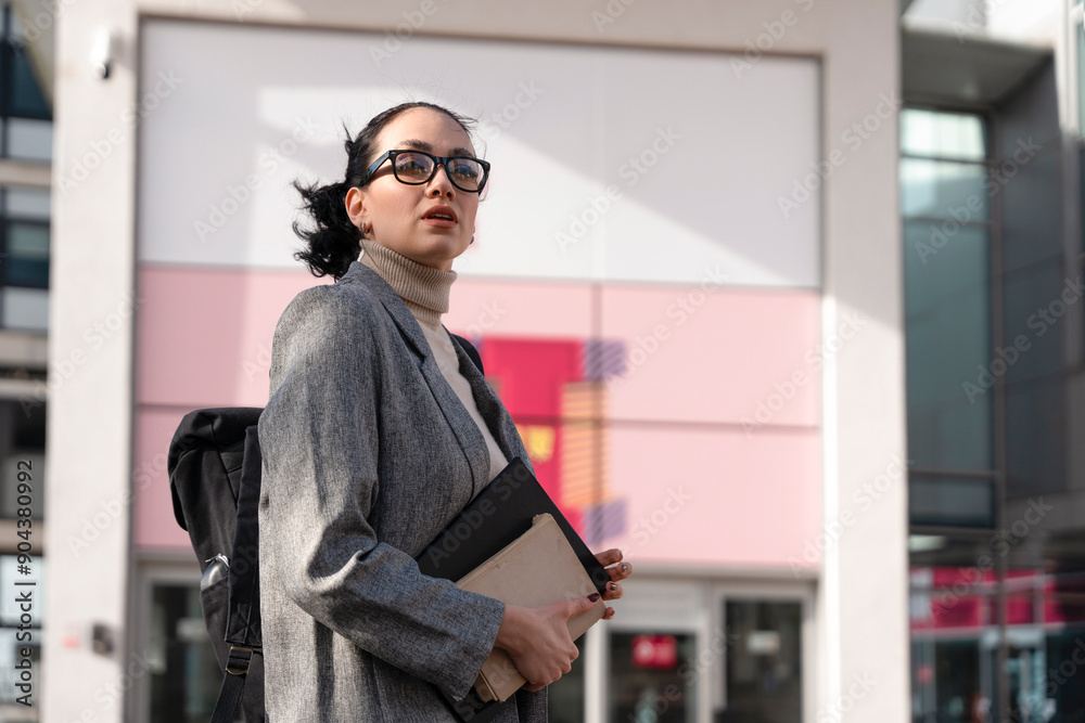 Young Professional Woman Holding Laptop and Notebook in Urban Setting During Daytime. Young Professional Woman Holding Laptop and Notebook in Urban Setting During Daytime.