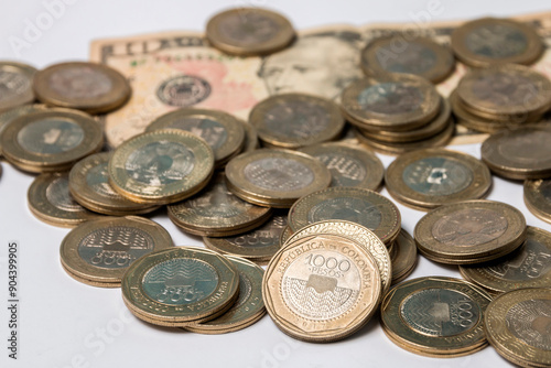 ten dollar bill and coins of one thousand Colombian pesos