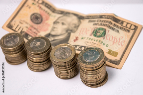 ten dollar bill and coins of one thousand Colombian pesos photo