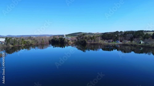 Envolé de drone sur l'eau bleue et miroir de l'embouchure de la rivière Matapédia à Amqui, Vallée de la Matapédia. Secteur agricole et résidentiel en harmonie avec la nature . photo