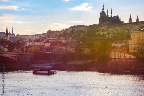 Boats on Vltava river and Hradcany castle in the background, in Prague, Czech Republic (Czechia), at sunset