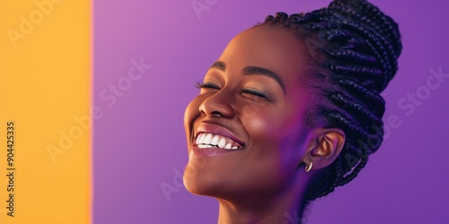 A woman with closed eyes, laughing and smiling widely, enjoying the moment.