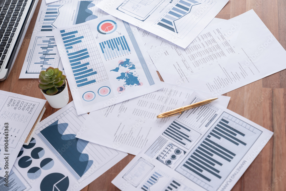 Obraz premium Piles of analyzed financial data dashboard on wooden office workspace desk. Business paper work with graph chart and analytic market trend indication data for strategic investment decision. Meticulous