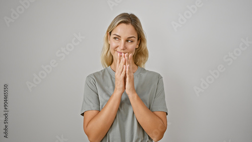 A contemplative young blonde woman in a grey t-shirt isolated against a white background.