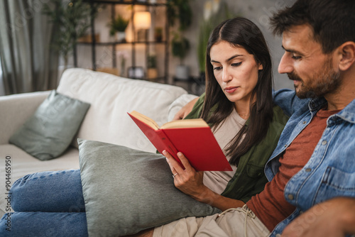 relax couple boyfriend and girlfriend sit on sofa and read a book