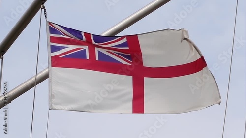 A British naval ensign on a warship of the Royal Navy., the naval flag of the United Kingdom. The flag features the Union Jack in the canton, with a red St. George's Cross.