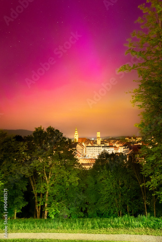 Northern lights in Poland, a colorful show in the night sky, a light phenomenon over the city of Bystrzyca Klodzka. View of the northern part of the sky from the city park.