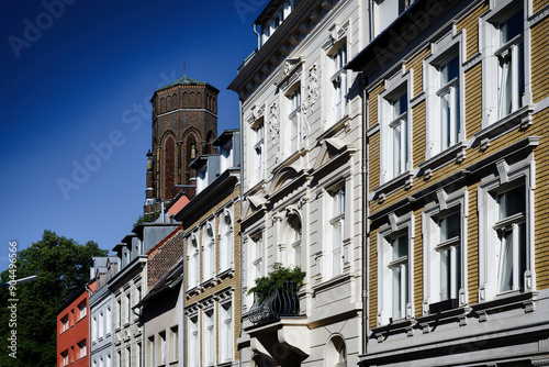 Fototapeta carefully restored pastel-colored old buildings in the cologne district of Lindenthal with the tower of St