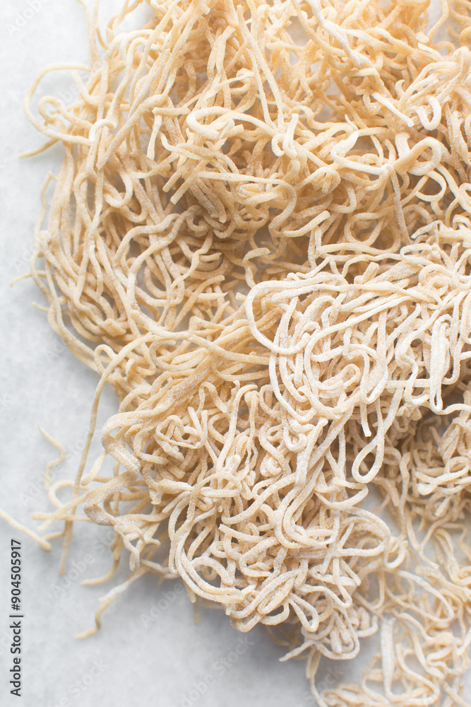 Overhead view of dried homemade egg noodles on a marble countertop, top view of air-dried egg noodles Overhead view of dried homemade egg noodles on a marble countertop, top view of air-dried egg noodles
