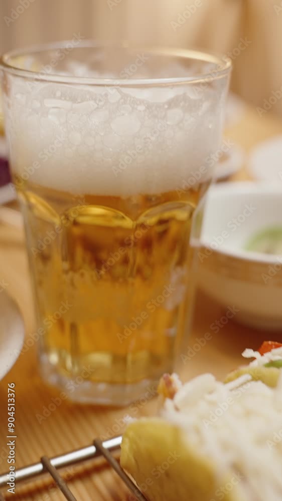 Vertical video. A Glass of Beer with a Foamy Head Stands on a Table Next to Freshly Prepared Tacos and Bowls of Ingredients. Vertical video. A Glass of Beer with a Foamy Head Stands on a Table Next to Freshly Prepared Tacos and Bowls of Ingredients.