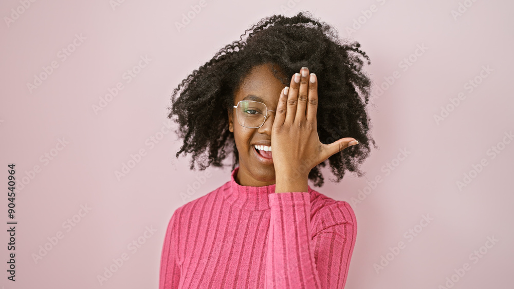 African american woman smiling indoors wearing glasses and a pink sweater African american woman smiling indoors wearing glasses and a pink sweater