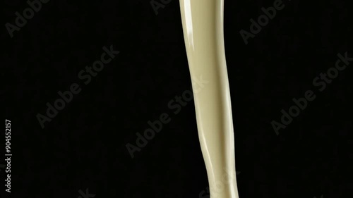 flow of milk with splash isolated on black background
