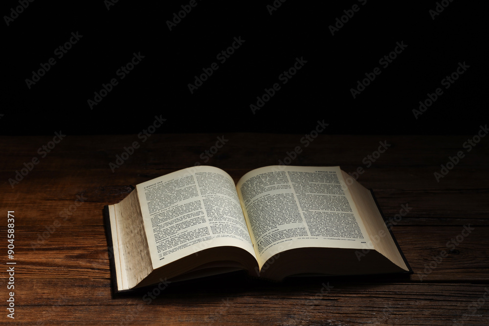 Bible on wooden table against black background, space for text. Religion of Christianity Bible on wooden table against black background, space for text. Religion of Christianity