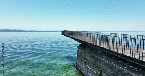 Wallpaper Mural A rustic pier extends over clear coastal waters beneath a blue sky on a calm day, a serene scene Torontodigital.ca