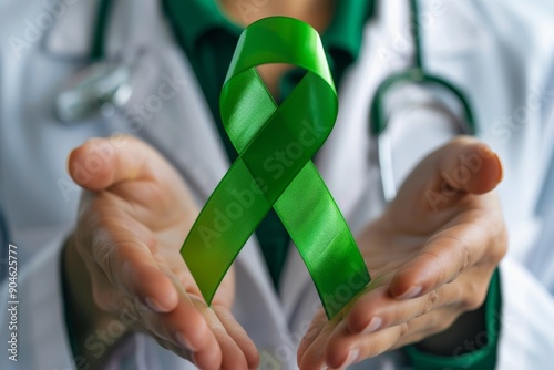 Doctor Holding Green Awareness Ribbon for Health and Medical Support Concept photo