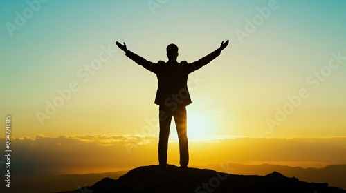 A silhouette of a businessman standing triumphantly on a mountain at sunrise, embodying success and achievement.