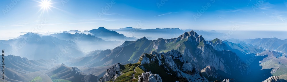 Fototapeta premium A mountain range with a blue sky and a sun in the background