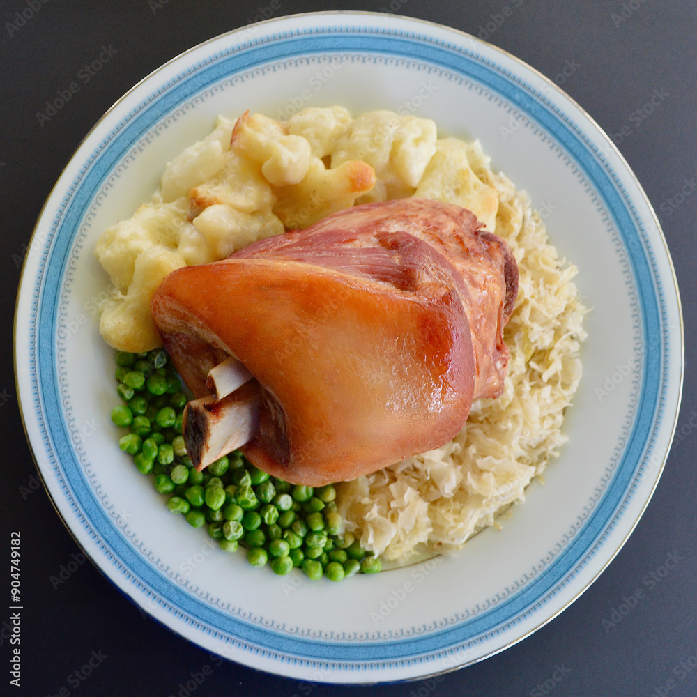German style pork knuckle with sauerkraut cauliflower bake and green peas. German style pork knuckle with sauerkraut cauliflower bake and green peas.