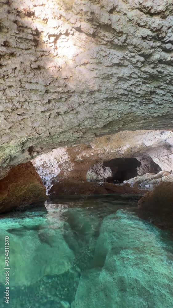 Inside sea cave grotto blue water flowing among rocks, vertical video Inside sea cave grotto blue water flowing among rocks, vertical video
