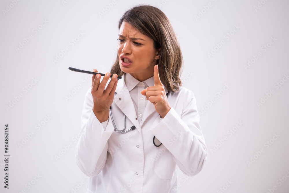 Portrait of angry doctor who is talking on phone with patient. Portrait of angry doctor who is talking on phone with patient.