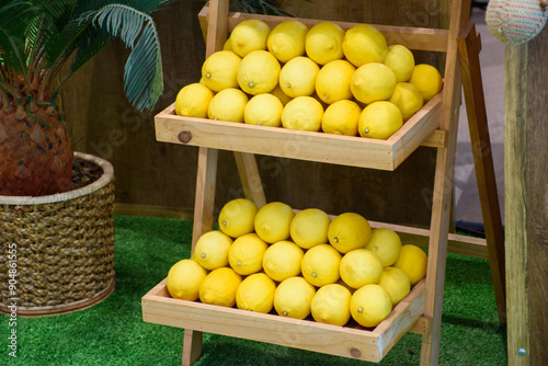 Group of lemons In a wooden box with a chalkboard sign with the message Lemon written on it. Lemons in a wooden box at the shop background.