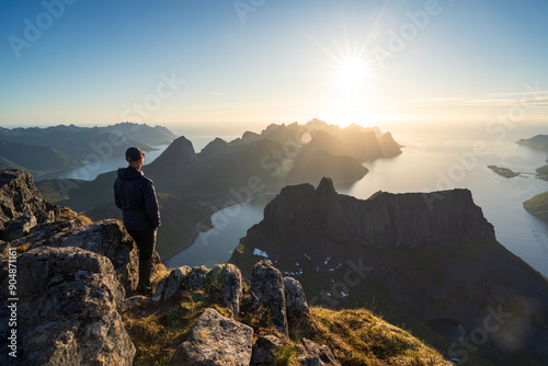 A man wachting the midnightsun on summit Grytetippen on Senja, Norway. photo