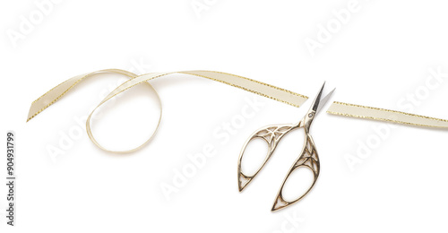 Scissors with cut ribbon on white background