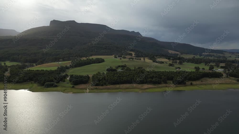 Houses on Huntsman Lake green shores in summer season, Tasmania in Australia. Aerial sideways and copy space Houses on Huntsman Lake green shores in summer season, Tasmania in Australia. Aerial sideways and copy space